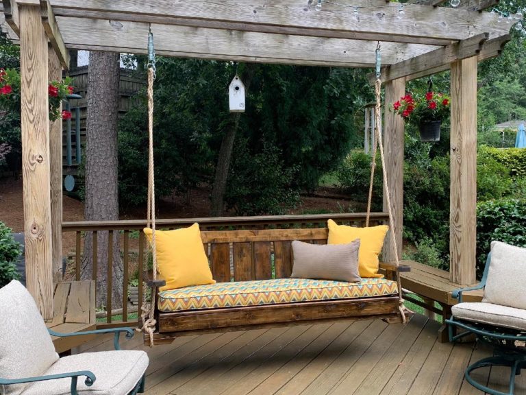 Porch swing with cushion, pillows, and rope
